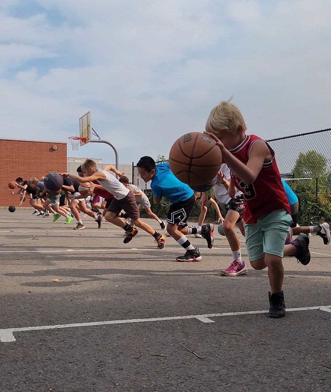 Young basketball players practicing dribbling and movement together